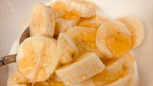 A bowl of sliced bananas with syrup. - Luxe Apartment - Stylish 2 Bedroom Apartment (Harrow)