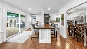 A spacious kitchen with a central island, modern appliances, and a view to a backyard. - Redwood Retreat Waterfront Cottage By Simcoe With Hot Tub And Sauna (Orillia)