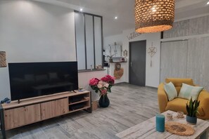 A modern living room with a flat-screen TV, a sofa, a coffee table, and a decorative vase with flowers. - Charming holiday house with private pool, Maillane (Maillane)