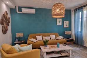 A living room with a sofa, a coffee table, and a hanging light fixture. - Charming holiday house with private pool, Maillane (Maillane)