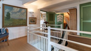 A room with a white crib, a painting of a landscape, and a green door. - charmante Ferienwohnung am Hafen (Tönning)