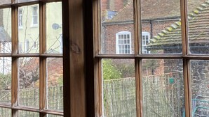 A view through a window with multiple panes, revealing a brick building with a chimney and a yellow wall. - Beautiful Haven Retreat in Sandwich (Sandwich)
