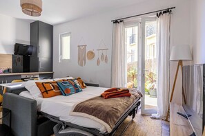 Ein modernes Schlafzimmer mit Bett, Nachttisch und Blick auf den Balkon.