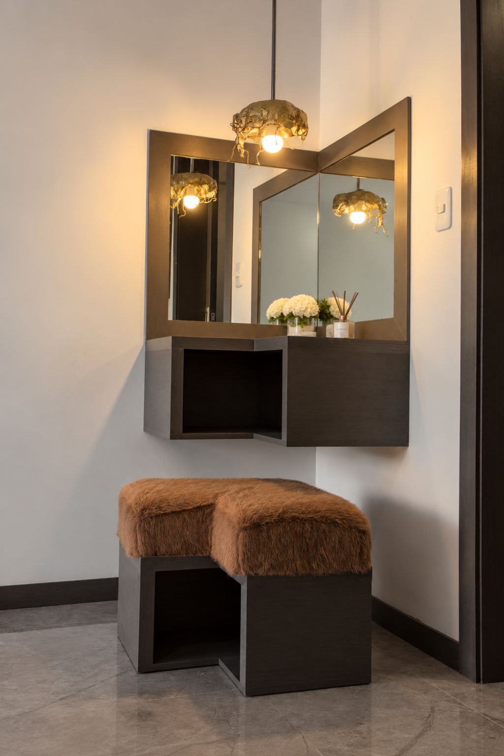 A modern bathroom with a large mirror, a bench, and a light fixture.