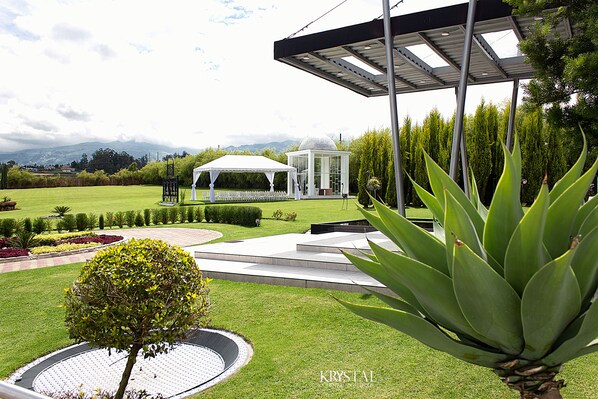 A well-maintained garden with a gazebo, a circular water feature, and a large agave plant. - HOTEL QUINTA KRYSTAL BOUTIQUE (Sangolqui)