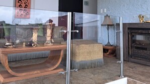 A modern living room with a glass partition, a fireplace, and a chandelier. - HOTEL QUINTA KRYSTAL BOUTIQUE (Sangolqui)