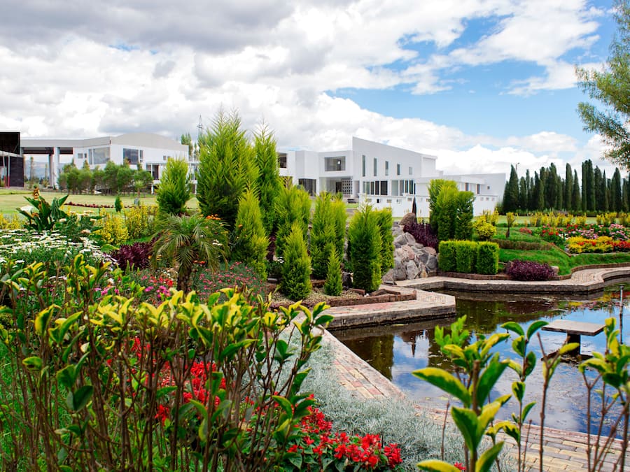 Un bâtiment moderne doté d’un jardin et d’un étang.