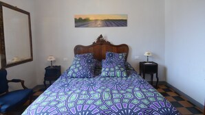 A bedroom with a large bed, two nightstands, a chair, a painting on the wall, and a mirror. - GREAT APARTMENT IN THE HISTORIC CENTER OF CAMAIORE (Camaiore)