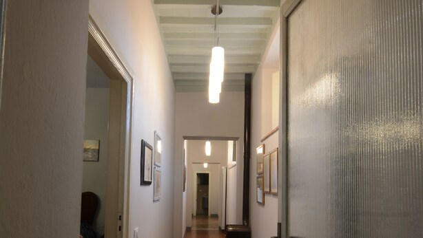 A hallway with a wooden floor, white walls, and a door with a frosted glass panel. - GREAT APARTMENT IN THE HISTORIC CENTER OF CAMAIORE (Camaiore)