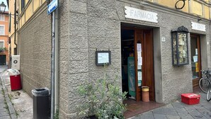 A pharmacy with a stone facade, a signboard, and a bicycle parked outside. - GREAT APARTMENT IN THE HISTORIC CENTER OF CAMAIORE (Camaiore)