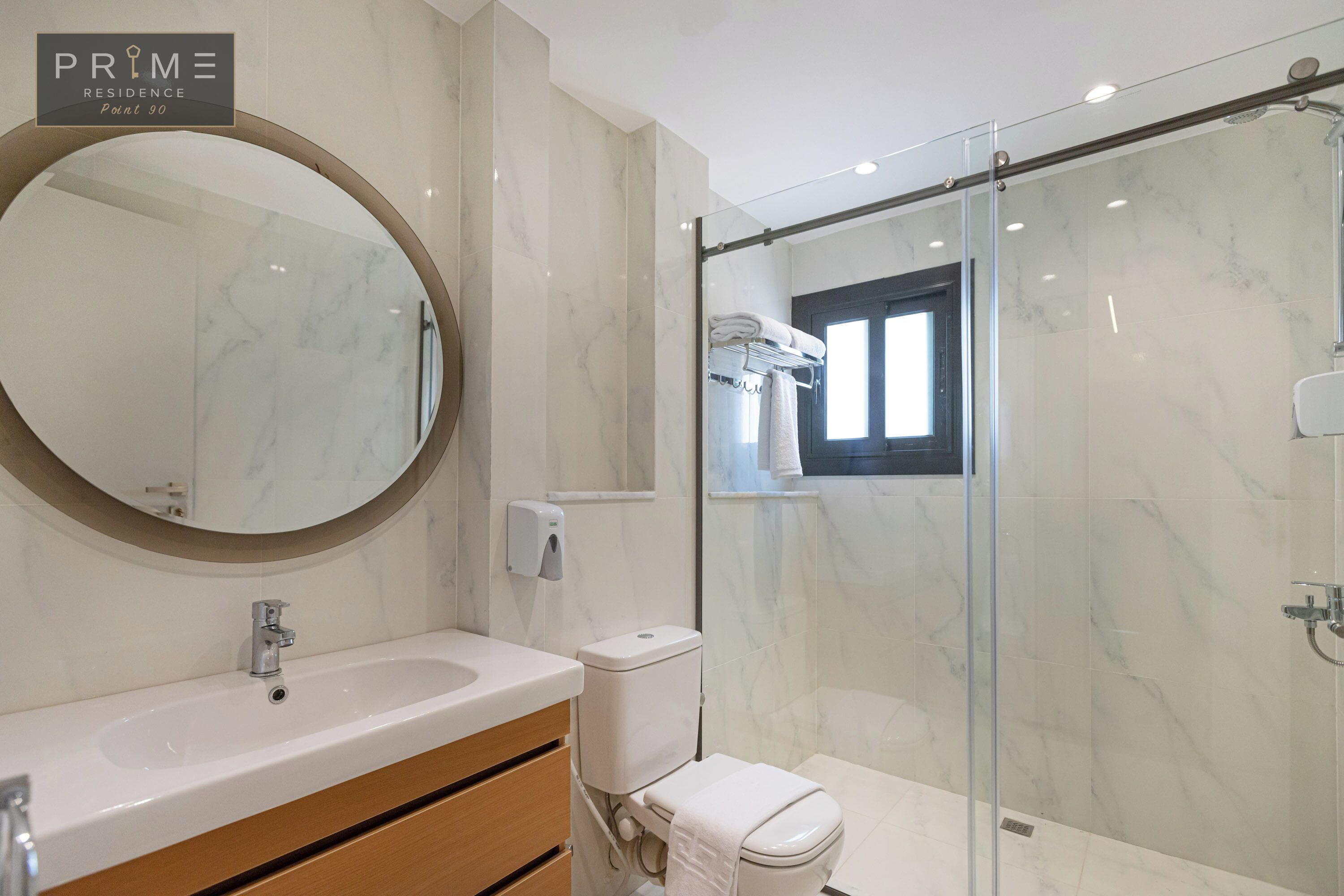 Une salle de bain moderne avec un lavabo en marbre, des toilettes et une douche à parois de verre.