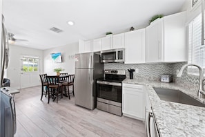 Enjoy cooking in this well-equipped kitchen with a refrigerator, oven, and microwave. Dine at the wooden table with a view of the surrounding greenery.