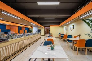 Une cafétéria avec de longues tables communes, des places assises individuelles et un espace buffet.