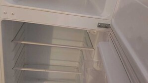 An empty refrigerator with two shelves and a door handle.