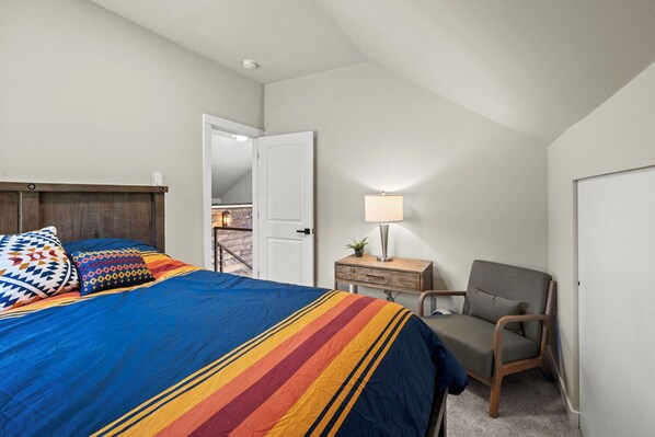 A bedroom with a bed, a chair, a desk, and a lamp. - Cabin at Rainier: New-AC-WiFi-Lg. Yard (Ashford)