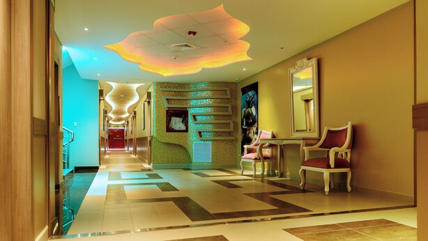 A hotel lobby with a modern design, featuring a patterned floor, a reception desk, and a seating area with chairs. - NP Hotel & Suites (Guayaquil)