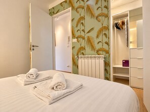 A hotel room with a bed, a wardrobe, and a bathroom.