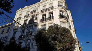 A multi-story building with balconies, a clear sky, and a street lamp. - Elegant Belle Époque Apartment in Central Menton (Menton)