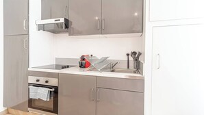 Une cuisine moderne dotée d’appareils électroménagers en acier inoxydable, d’un four encastré et d’un évier avec un égouttoir.