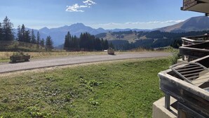 Vista de varanda com uma estrada e montanhas ao longe.