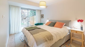 A bedroom with a bed, a nightstand, a lamp, and a window with curtains. - magnificent 2-room apartment  sea view Roquebrune (Roquebrune-Cap-Martin)