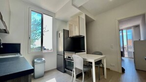 Eine kompakte Küche mit Essbereich, einem Fernseher und Blick ins Freie.