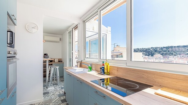 A modern kitchen with a large window, a built-in stove, and a view of the city. - Superb  Rooftop Roquebrune Parking (Roquebrune-Cap-Martin)
