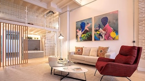 A modern living room with a red armchair, a white sofa, and two paintings on the wall. - Genteel Home Santas Patronas V (Seville)