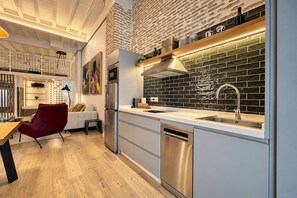 A modern kitchen with a stainless steel refrigerator, a built-in oven, and a sink with a modern faucet. - Genteel Home Santas Patronas V (Seville)