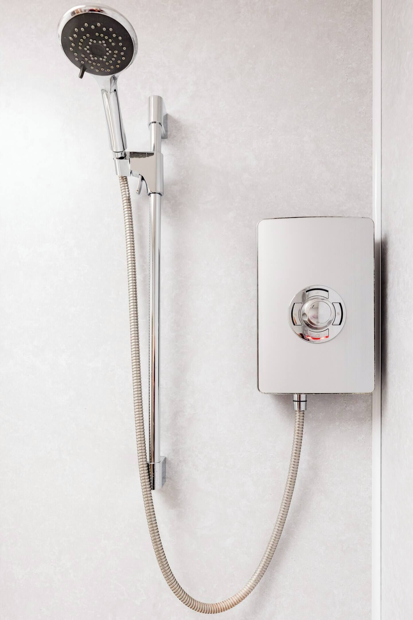 Une douche murale dotée d’un pommeau de douche à main et d’un panneau de commande.
