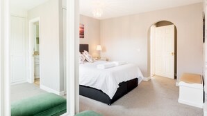 A bedroom with a bed, bedside table, lamp, and a green bench. - Pass the Keys | Spacious 4Bed Warwick Family Home, with Parking (Warwick)