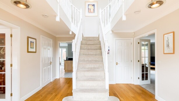 A staircase with a carpeted landing and white railings, leading to a second floor. - Pass the Keys | Spacious 4Bed Warwick Family Home, with Parking (Warwick)