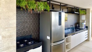 A modern kitchen with a stainless steel refrigerator, a built-in stove, and a geometric backsplash. - PUERTO VENTURA Flat by Penareia.tur.br (João Pessoa)