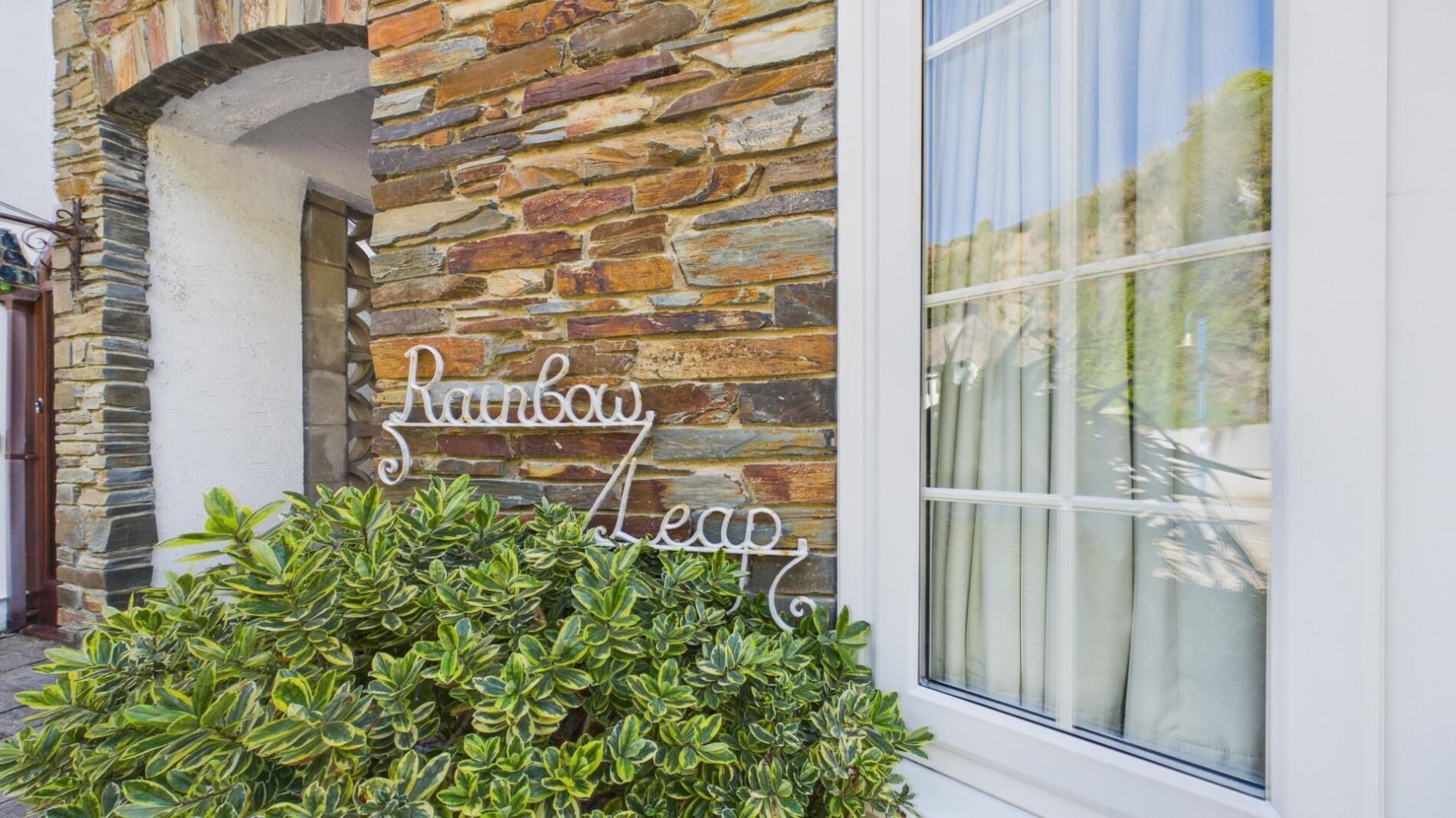 A stone building with a sign that reads 'Rainbow Leap.'