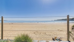 A beach with a volleyball net, a chair, and a blanket.