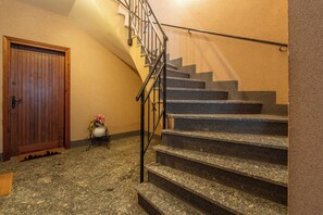 A staircase with a handrail, a wooden door, and a small table with flowers. - Magic View - Love Escape for Two (Tremezzo)