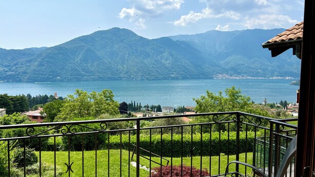 A balcony with a view of a lake, mountains, and a town in the distance. - Magic View - Love Escape for Two (Tremezzo)