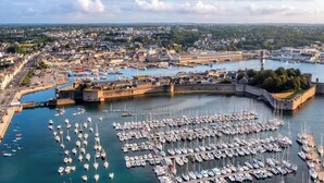 A harbor with numerous boats docked, a fortified structure, and a cityscape in the background. - -PICCO BIANCO-STUDIO ENTIÈREMENT RÉNOVÉ-CONCARNEAU (Concarneau)