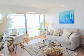 Una sala moderna con sofá, mesa de centro y comedor.