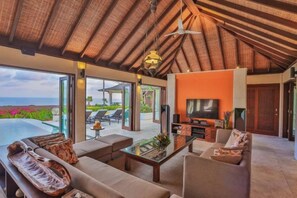 A spacious living area with a large sofa, a coffee table, and a television. - Villa Cantik Pandawa By Fays Hospitality (Bali)