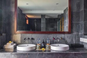 A bathroom with two sinks, a large mirror, and a shower visible in the reflection. - Villa Cantik Pandawa By Fays Hospitality (Bali)