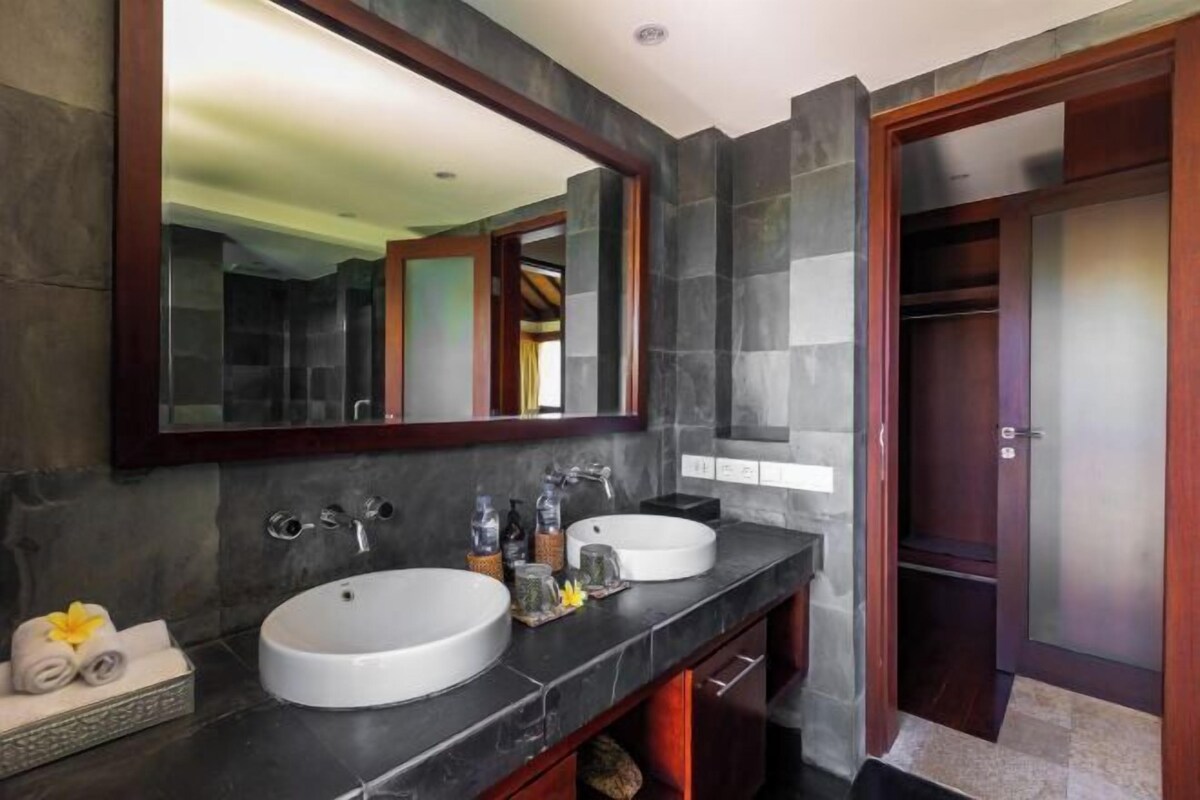 A bathroom with two sinks, a large mirror, and a wooden door.