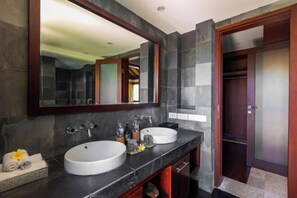 A bathroom with two sinks, a large mirror, and a wooden door. - Villa Cantik Pandawa By Fays Hospitality (Bali)