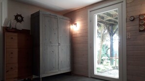 Une pièce avec un meuble en bois, une porte donnant sur l’extérieur et une horloge murale.