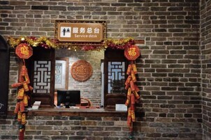 Mostrador de atención al cliente con un letrero, una computadora y decoración tradicional.