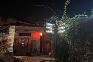 A stone building with a signpost indicating directions to various facilities.