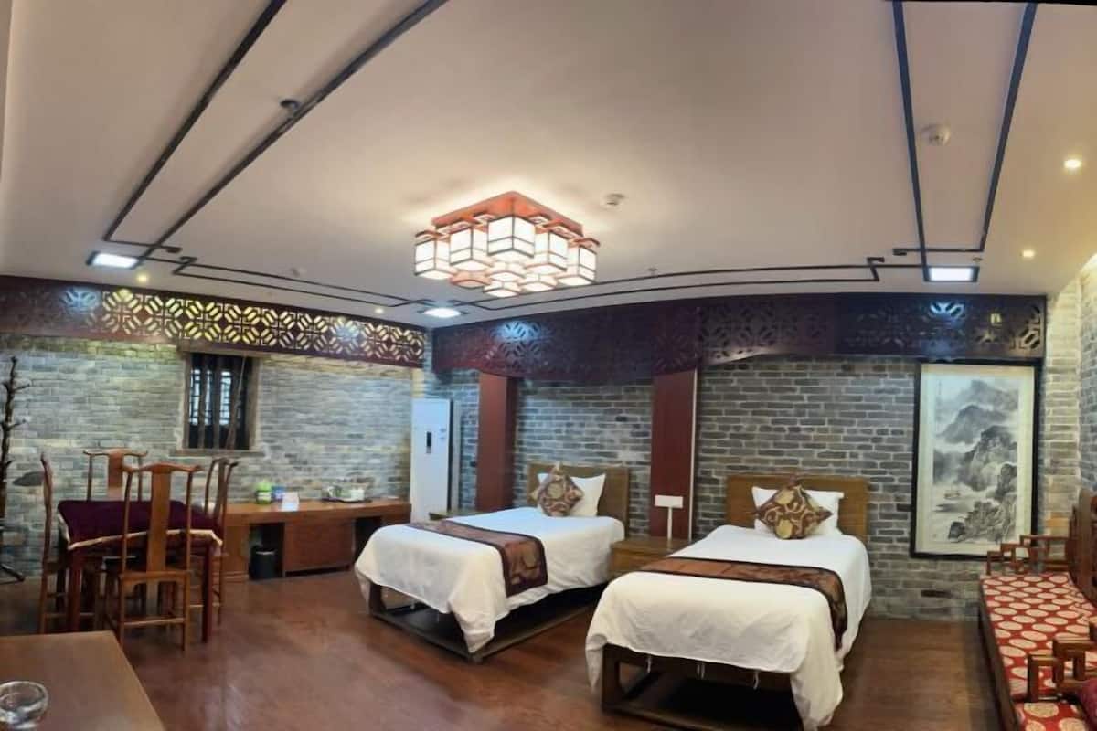 Habitación de hotel con dos camas, un escritorio y un comedor.