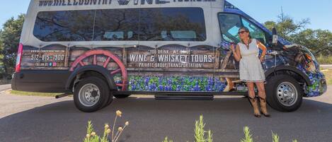 A large van with "Hill Country Wine Tours" branding, a contact number, and a website URL.