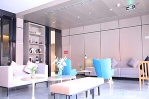 A modern lobby with seating areas, a reception desk, and a bookshelf. - Jinjiang Inn Select (Wenzhou High-speed Railway Station Xinqiao) (Wenzhou)