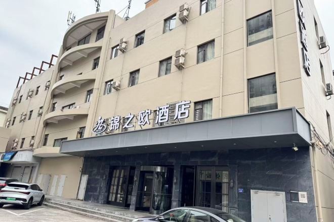 A hotel with a modern facade, multiple floors, and a prominent entrance.